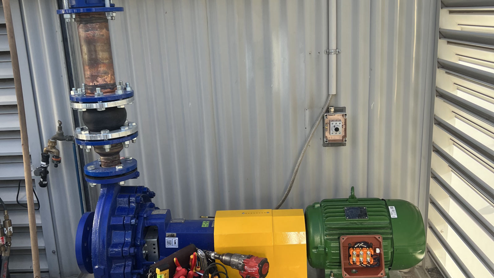 Industrial pump and motor installation with the motor terminal box opened for electrical connection