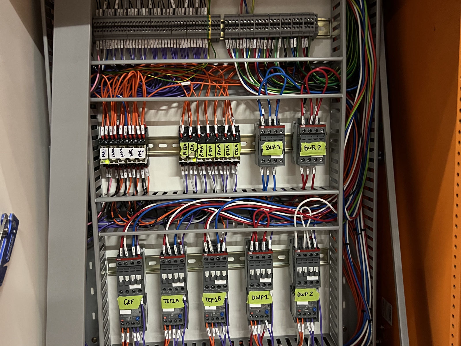 Motor control panel being wired, showing labelled contactors, relays and terminal rails